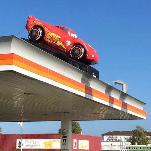 aufblasbares Auto auf dem Dach von Coop Tankstelle