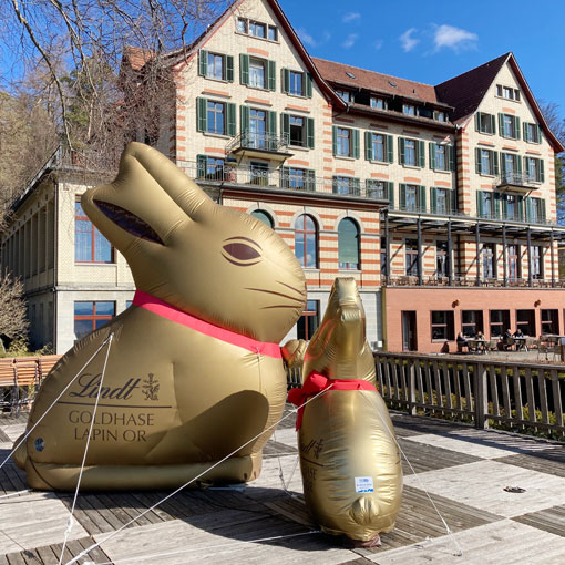 aufblasbarer goldiger Osterhase von Lindth steht auf einer Aussichtsterrasse
